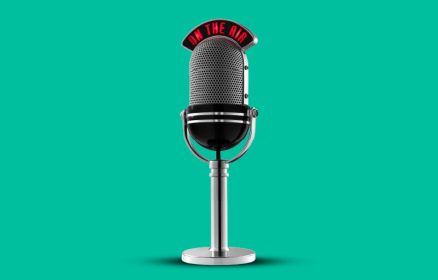 Retro silver microphone on a stand with an 'ON THE AIR' sign above, against a teal background.
