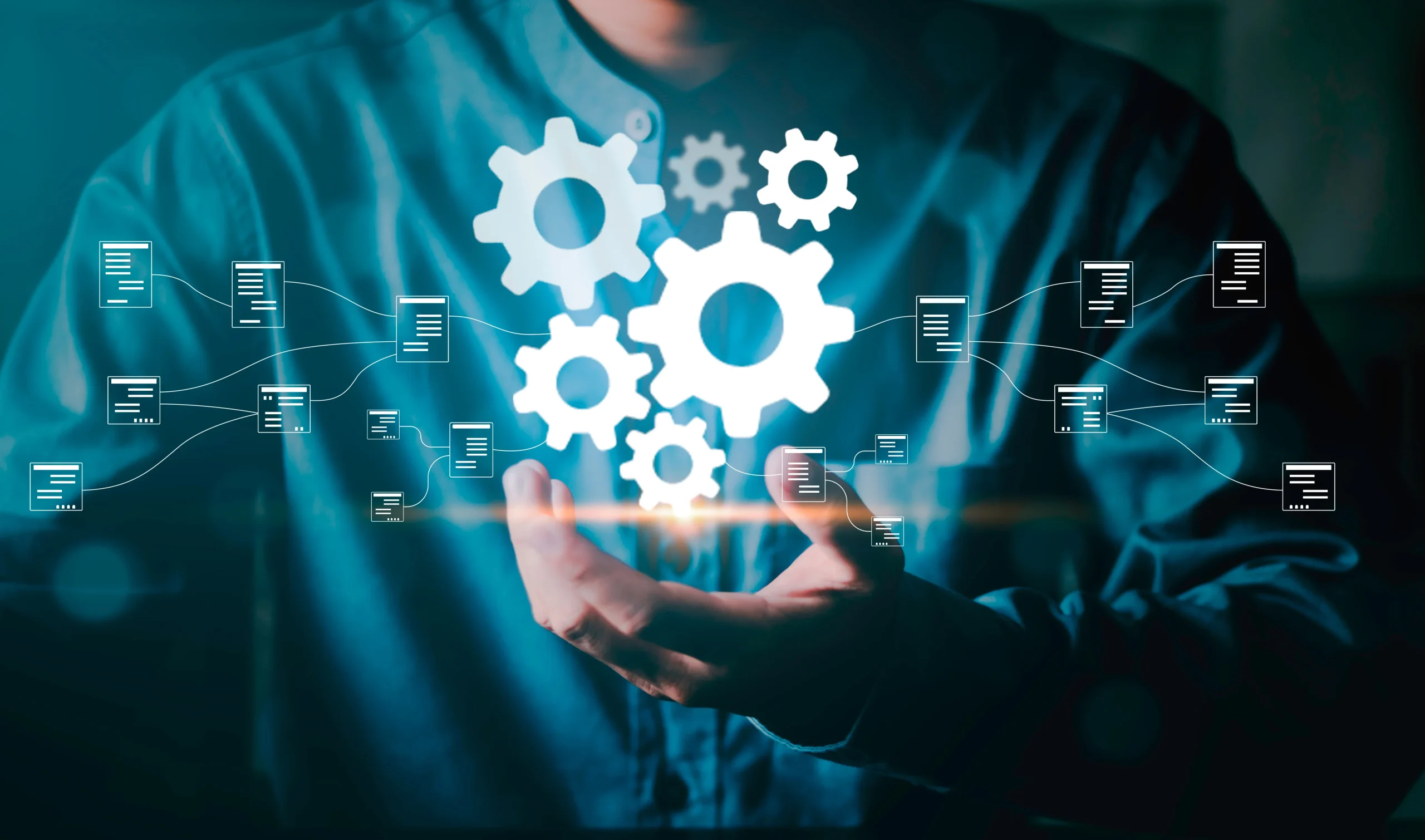 Hands under floating gears and network icons, illustrating automation and connectivity in tech systems